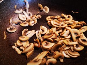 pulite i funghi, tagliateli e rosolateli in olio e aglio