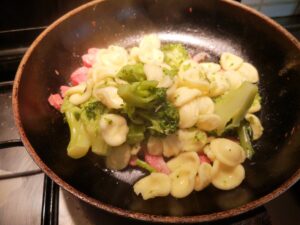 amalgamante le orecchiette con le cime di broccoli e pancetta