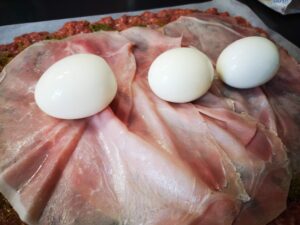 aggiungete il prosciutto le uova sode al centro