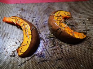 Lavate la zucca e sistematela su una leccarda rivestita di carta forno o di un tappetino in silicone; Cospargetela con sale, pepe, rosmarino e un filo d'olio;