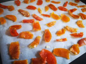 sistemate le bucce di mandarino caramellate su un foglio di carta forno